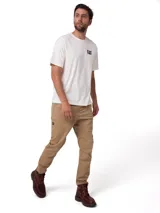Pantalon Caterpillar de twill elastizado en color beige, con bolsillos laterales tipo utilitario, detalle de etiqueta con logo de la marca y corte ajustado.