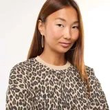 Buzo de cuello redondo con estampado de leopardo, mangas largas y puños y ruedo en tejido rib color beige.