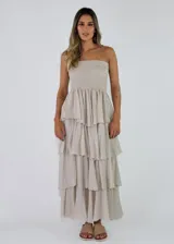 Vestido largo strapless de color crudo con diseño de múltiples volados escalonados y cuerpo fruncido elástico.