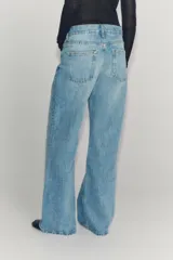 Jeans de tiro bajo y pernera flare, confeccionados en denim de algodón con efecto lavado claro. Presenta diseño clásico de cinco bolsillos, trabillas para cinturón y cierre frontal con cremallera y botón metálico.