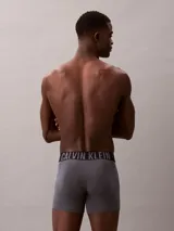 Pack de tres bóxers tipo boxer brief de Calvin Klein, con cintura elástica distintiva de la marca. Incluye una unidad azul, una blanca y una gris.