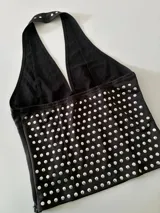 Top negro con escote halter y estampado de lunares plateados.