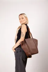 Bolso tote de cuero color marrón con doble asa de mano.