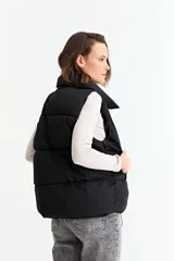 Chaleco puffer de corte holgado y diseño acolchado, con cuello alto y cierre frontal oculto. Presenta cordón ajustable en el ruedo inferior y bolsillos laterales.