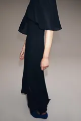 Vestido largo de punto color negro, con escote en V pronunciado tanto en el delantero como en la espalda, y mangas cortas anchas con vuelo.