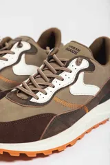 Zapatillas deportivas color crema con detalles en beige, negro y blanco.