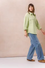 Jean de tiro medio con diseño de pierna amplia tipo wide leg, calce relajado y lavado celeste, con costuras frontales destacadas.