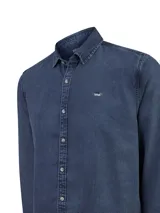 Camisa de tencel de manga larga de RKF, en color azul oscuro con efecto desteñido. Presenta cuello camisero, cierre frontal con botones carey y un pequeño logo bordado de un pato en el pecho.