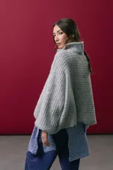 Buzo tejido en mohair de color gris, con silueta amplia y corte en línea A. Presenta cuello tipo remera con broches que permiten cerrarlo como polera, mangas largas con puños y un diseño de tejido horizontal.