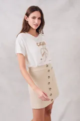 Minifalda color beige de tejido de punto con bolsillos delanteros y cierre frontal con botones.