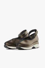 Zapato negro con base deportiva y pulsera al tobillo ajustable. Parte superior de tela satinada, forro y plantilla de piel de cerdo y suela de goma.