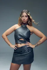 Top marrón de símil cuero con cuello alto ajustable con hebilla metálica y cierre en la espalda.