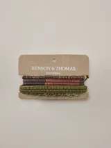 Set de pulseras Benson & Thomas modelo Larnaca en tonos verdes y marrones, compuesto por cuatro tiras con diferentes texturas, incluyendo cuentas de madera y cordones tejidos.