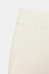 Bermudas de tiro medio y cintura ancha, color marrón, con bolsillos delanteros y cierre frontal con cremallera y ganchos metálicos.