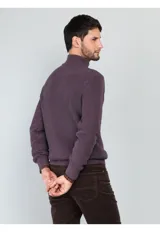 Sweater de punto en color beige, con cuello alto y cierre frontal parcial. Diseño de manga larga con puños y ruedo acanalados.