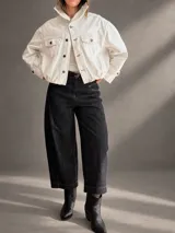 Jeans barrel de tiro alto, confeccionados en denim azul muy oscuro casi negro, con pespuntes contrastantes, diseño de pierna amplia y redondeada, y bolsillos delanteros.
