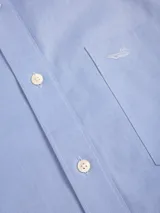 Camisa de manga larga Rockford en color azul, con cuello abotonado, bolsillo frontal con logo bordado y cierre de botones. Presenta un tejido con textura de espiga.