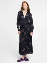 Vestido camisero largo negro con estampado de tigres en color lila, con cuello camisero, mangas largas y lazo en la cintura.