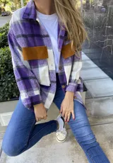 Camisa leñadora a cuadros color lila, blanco y negro, con bolsillos de parche en cuero color marrón.