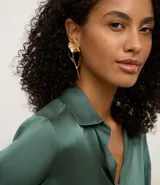 Par de caravanas doradas de metal reciclado, con diseño asimétrico de flor. Una caravana presenta una flor completa con tallo alargado, mientras que la otra tiene un solo pétalo.