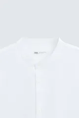 Camisa negra de lino y algodón, corte relaxed fit, cuello mao, manga larga con puños abotonados y cierre frontal con botones.