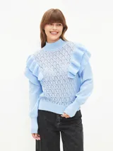 Buzo de punto color celeste con cuello alto, diseño de tejido calado en el frente y volados en los hombros. Presenta mangas largas con puños acanalados.