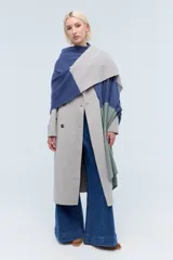 Ruana tejida de punto con bloques de color beige y marrón. Confeccionada en lambswool.