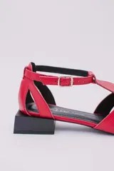 Sandalias de cuero estilo jaula en color rojo, con punta cuadrada, taco cuadrado bajo en color negro y cierre con hebilla ajustable en el tobillo.