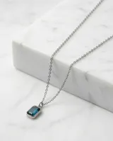 Collar de acero con cadena fina y dije rectangular con circonia color azul profundo en engaste biselado.