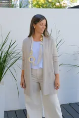 Saco tipo cárdigan abierto de corte recto y largo medio, color visón, con mangas largas y bolsillos frontales aplicados.