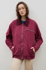 Campera de jean azul oscuro con cuello de pana en color crema. Presenta cierre frontal metálico, bolsillo con cierre en el pecho y bolsillos laterales. Diseño de corte holgado con mangas largas.