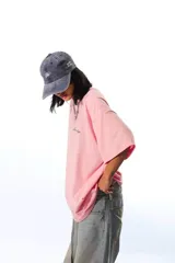 Remera de algodón peinado color rosa, de corte holgado y manga corta, con un pequeño bordado en el pecho.