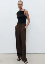 Pantalon de vestir color marrón, de corte wide leg, con tiro medio, pinzas delanteras, trabillas para cinturón y bolsillos laterales.