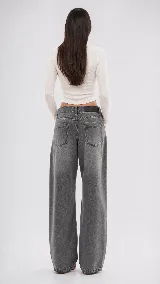 Pantalón de jean color naranja con tiro medio, diseño de pierna ancha y cinco bolsillos. Presenta costuras con pespuntes a contratono.