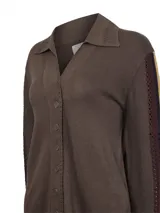 Sweater de punto color marrón con cuello camisero y cierre frontal de botones. Presenta detalles de tejido calado en las mangas con franjas laterales en contraste y terminaciones en crochet en el cuello y la tapeta.