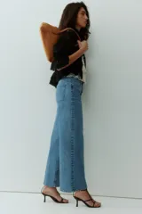 Jean tobillero de cinco bolsillos en denim de mezcla de algodón y viscosa con leve stretch. Piernas amplias, corte estándar de cintura a cadera y corte holgado de muslo a bajo, con cintura de tiro alto, cierre y botón.
