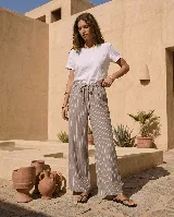 Pantalón ancho de lino con diseño a rayas verticales, cintura elástica con cordón de ajuste y bolsillos laterales.