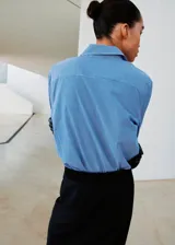 Camisa de corte recto confeccionada en mezcla de algodón y lyocell, con diseño de rayas finas, cuello camisero, manga larga con puños abotonados y cierre frontal de botones.