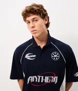Remera polo de hombre azul marino con detalles en blanco, mangas cortas y corte boxy. Presenta estampas deportivas frontales con las leyendas "Radar" y "Anthem", además de recortes laterales en contraste y cuello con botones.