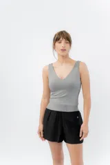 Top ajustado color gris claro, con escote en V pronunciado tanto en el frente como en la espalda, y tirantes anchos.