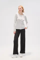 Cardigan de algodón color gris melange, con cuello redondo, cierre frontal con botones y mangas largas.