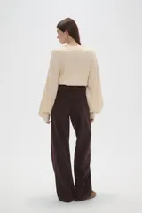 Pantalon de jean de corte ancho y tiro medio, en color natural, con cierre frontal y bolsillos laterales.
