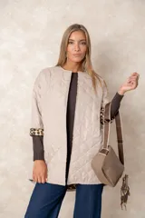 Cartera bandolera color chocolate con textura granulada, que incluye un monedero circular desmontable sujeto a la correa. Posee cierre superior y correa ajustable con detalles en color crema.