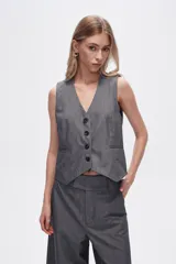 Chaleco gris sin mangas con cuello en V y cierre frontal con botones.