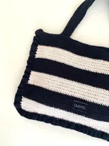 Bolso tipo tote tejido a crochet con hilo de algodón color marrón y crudo, con diseño a rayas horizontales y volados en los bordes.