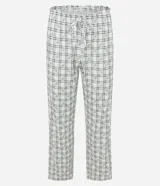 Pijama largo de dos piezas confeccionado en tejido peach touch, con estampado de cuadros y pequeños detalles florales. Incluye una blusa de manga corta con escote en V, frunce en el busto y bordes ondulados, y un pantalón de corte recto con cintura elástica y cordón ajustable.