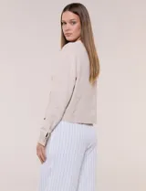 Camperita de tela liviana color beige, de silueta entallada con cuello a la base y abotonadura frontal con botones a tono. Cuenta con dos bolsillos con solapa en el frente, mangas largas con puños abotonados y largo a la cintura.