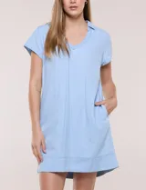 Vestido corto de lino color celeste con cuello camisero, escote en V, mangas cortas, bolsillos laterales invisibles y silueta holgada.