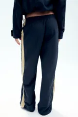 Pantalón de tiro medio azul marino con cintura elástica y bandas laterales en tono tostado a contraste, con diseño de pierna ancha.
