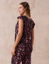 Conjunto de pijama marca René Rofé, compuesto por una remera de escote en V con botones y un pantalón capri con cintura elastizada, ambos en tejido soft estampado con motivos florales en tonos celeste y blanco.